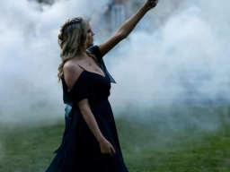 Bridemaid in pueple dress holding a burning flare