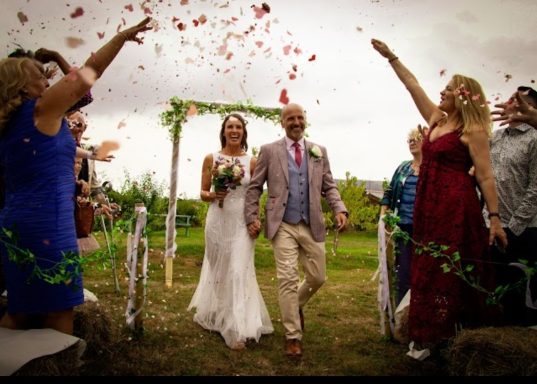 Couple just married wald trhough cloud of confetti