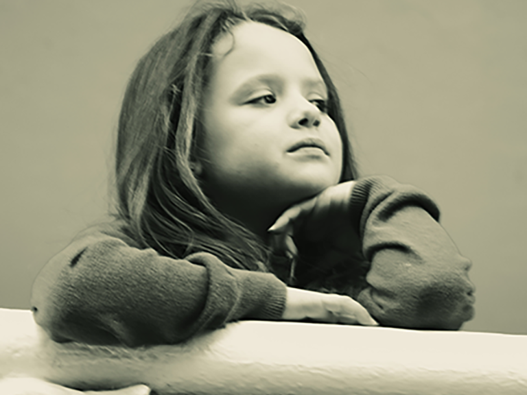 Soft black and white image of a young girl deep in thought