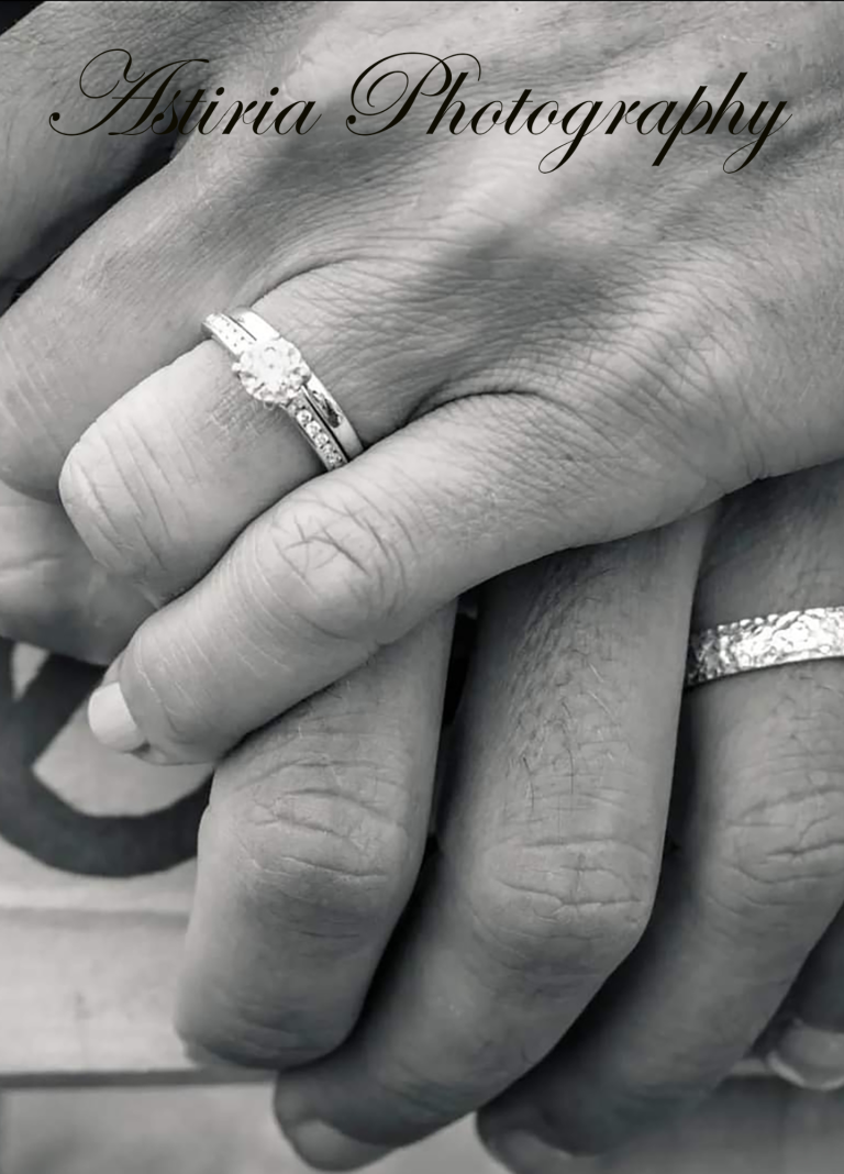 Close up of wedding rings as newly married couple hold hands