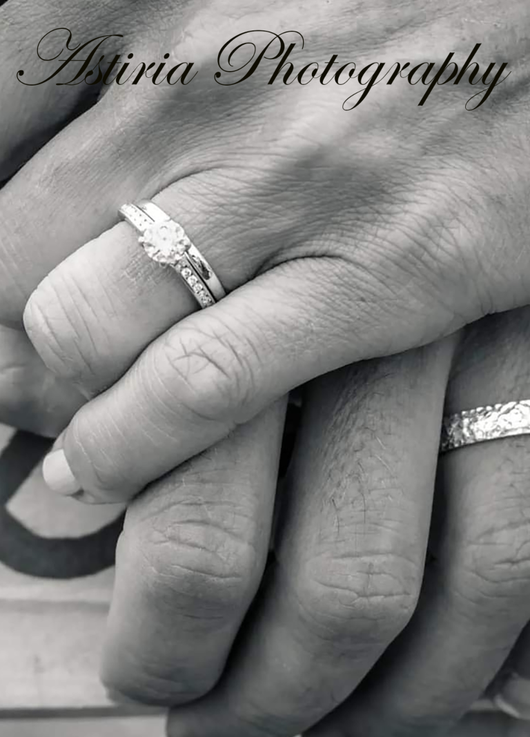 Close up of wedding rings as newly married couple hold hands