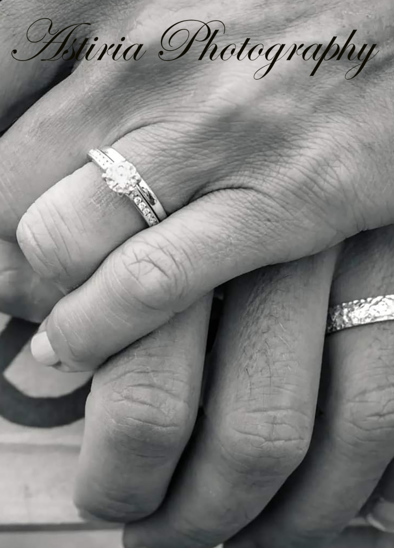 Close up of wedding rings as newly married couple hold hands