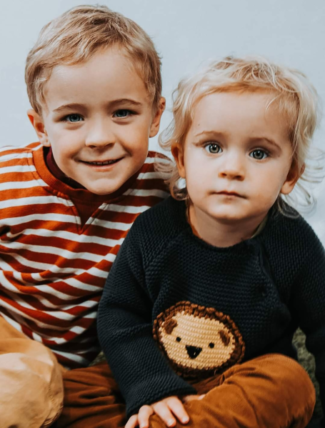 Two young boys in jumpers smiling at the camera